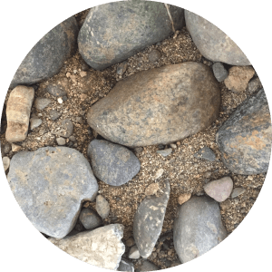 An up close view of very fine sand mixed with pebbles and small to medium sized cobbles.